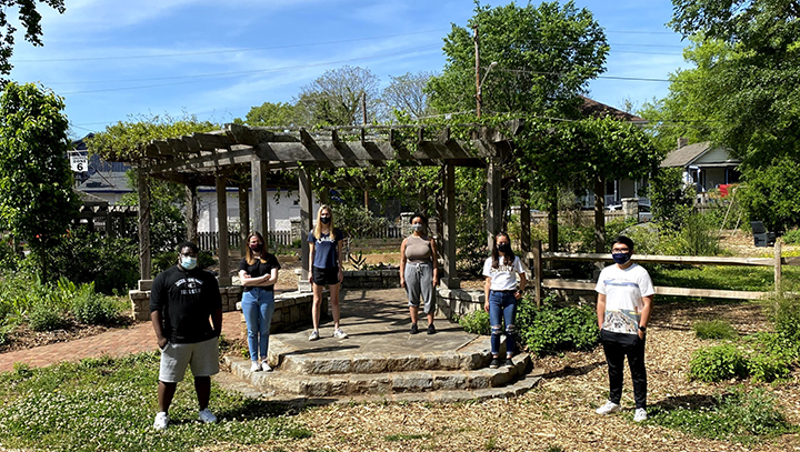 Emory inspired student participants standing masked before a gazebo